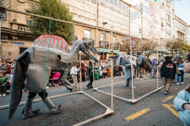 Santiago de Compostela, İspanya, 4 Mart 2025: Dinazor kostümleri giyen katılımcılar Santiago de Compostela, İspanya 'daki karnaval geçidinde yürüyorlar