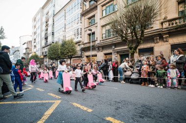 Santiago de Compostela, İspanya, 4 Mart 2025: Çocuklar Noel Baba İspanya 'da düzenlenen geleneksel karnaval yürüyüşü sırasında şenliklerin ve mobiletlerin keyfini çıkarıyorlar.