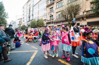Santiago de Compostela, İspanya, 4 Mart 2025: Renkli şeker kostümlü çocuklar Santiago de Compostela 'daki karnaval kutlamaları sırasında bir sokak gösterisinin canlı atmosferinin tadını çıkarıyorlar