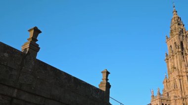 Santiago de Compostela Katedrali 'nin taş kiremitleri ve süslü kuleleri parlak mavi gökyüzüne karşı yükseliyor.