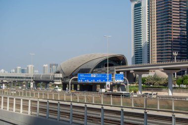 Benzersiz bir mimari tasarıma sahip, hareketli bir kentsel alanda modern bir metro istasyonu. İstasyon yüksek gökdelenlerle çevrili ve banliyö sakinleri için açık bir yön işareti var..