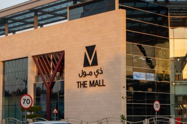 Büyük camlı pencereleri ve belirgin bir logosu olan modern bir alışveriş merkezi. Bina iyi ışıklandırılmış, hem Arapça hem de İngilizce 'de' The Mall 'yazan çağdaş bir mimari tasarım sergiliyor..