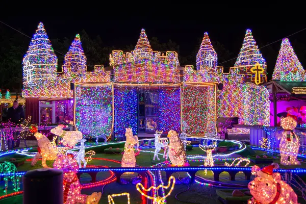 Rengarenk bir kaleyi aydınlatan ve geceleri dekorasyonları çevreleyen canlı bir ışık gösterisi. Sahnede çeşitli aydınlanmış figürler ve yapılar var, büyülü bir atmosfer yaratıyorlar..