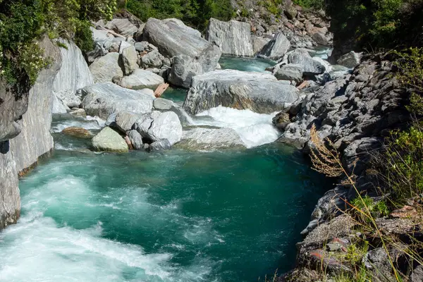 Kayalık arazide akan temiz turkuaz su ve büyük kayaların yer aldığı manzaralı bir nehir. Bereketli yeşillik nehir kenarlarını sarar ve sakin bir doğal ortam yaratır..