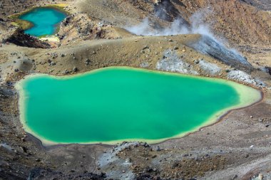 Kayalık arazi ve buhar bacalarıyla çevrili canlı turkuaz göllerin hava manzarası eşsiz jeotermal manzarayı gözler önüne seriyor..
