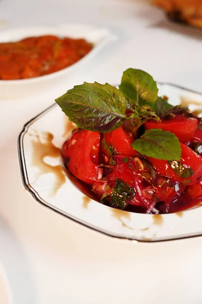 Stock image Tomato Salad with cherry red tomatoes, topping balsamic sauce and basil on white plate. Healthy food. Fresh salad bowl.