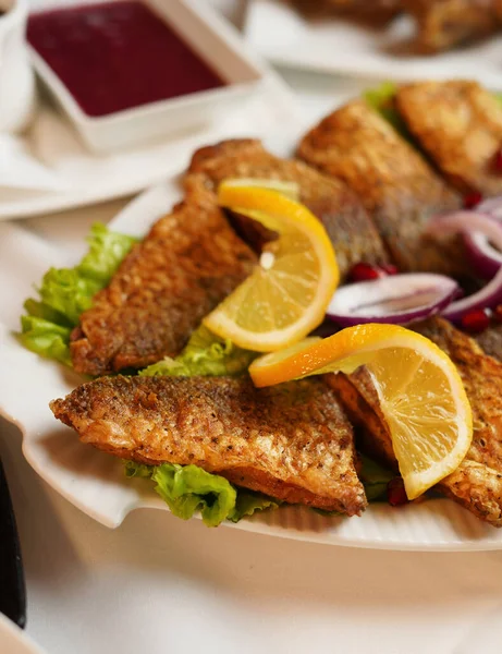 Beyaz tabakta sebzeli kızarmış balık. Lezzetli ve baharatlı balık kızartması. 
