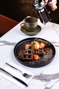 Dondurmalı çikolatalı waffle ve Fransız presi çayıyla servis edilen böğürtlenli.