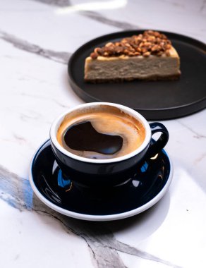 Fındıklı fındıklı kahve mermer masada dilimlenmiş peynirli kek.