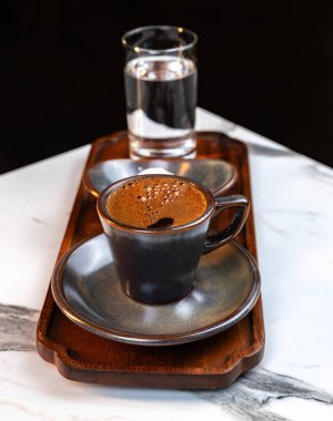 Otantik Türk Kahvesi Seramik Kupada bir bardak su ve tahta tepside geleneksel Lokum ile servis edilir