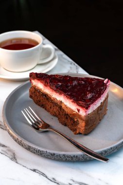 Bir dilim çikolatalı ahududu keki. Zarif Mermer Yüzeyde Çay