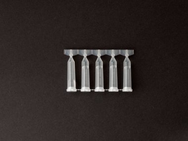 Tek kullanımlık göz damlaları koyu arka planda izole edilmiş. Göz damlası paketi tek kullanımlık konteynırlar. Göz bakımı konsepti. kuru göz tedavisi. Üst manzara, düz uzanma