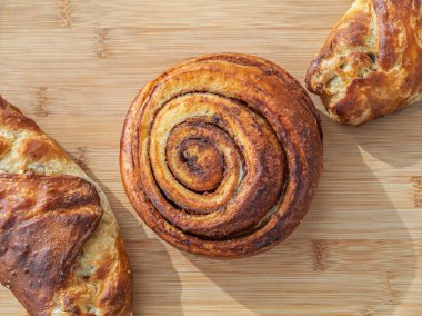 Tarçınlı çörek, Fransız kruvasanı. Tatlı çöl, menü ya da fırın kullanımı için ahşap arka planda klasik pasta görüntüsü. Üst manzara, düz uzanma