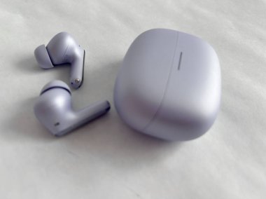 Yeşil arka planda kablosuz kulaklık. Kablosuz mini kulaklık şarj kutusunda. Yüksek kalite fotoğraf