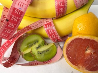 Hayat, parlak meyveler, sağlıklı yiyecekler. Yüksek kalite fotoğraf. Muzlu kivi ve mezura.