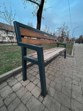 Siyah ve kahverengi çerçeveli bir bank tuğla bir geçitte duruyor. Huzur ve sükunet kavramı, banka oturmak için sessiz bir yer olduğu için. Yüksek kalite fotoğraf