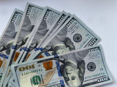 Mor bir yüzeye yayılmış yüz dolarlık banknotların yakın çekim hayranı. Finans, para, zenginlik ve finansal planlamanın sembolü. İş, ekonomi ve yatırım görselleri için kullanışlı