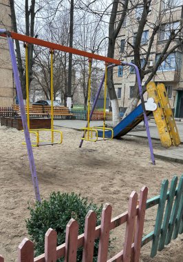 Küçük bir oyun alanı, evin avlusunda, anaokulunun arka planında, kaliteli bir fotoğraf.