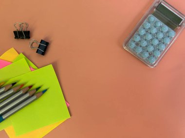 Renkli arka planlarda çeşitli okul ve ofis malzemelerinin yer aldığı canlı bir düz resim koleksiyonu. Her resim yapışkan notlar, kalemler, hesap makineleri, cetveller ve klipler gibi öğeleri içerir