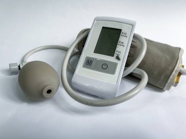 Beyaz arka planda dijital tansiyon monitörü. Evde ya da klinik ortamlarda atardamar basıncını ölçmek için tıbbi cihaz. Sağlık hizmetleri ve sağlık konuları için ayrı bir nesne. Yüksek kalite