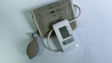 Beyaz arka planda dijital tansiyon monitörü. Evde ya da klinik ortamlarda atardamar basıncını ölçmek için tıbbi cihaz. Sağlık hizmetleri ve sağlık konuları için ayrı bir nesne. Yüksek kalite
