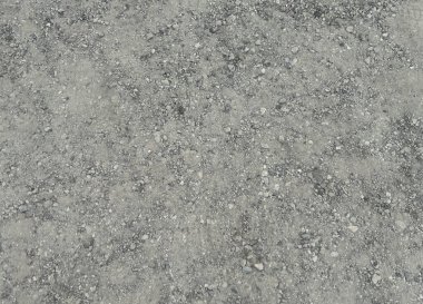 Yol yüzeyinde sıkıştırılmış çakıl ve asfalt karışımının yakın çekim dokusu. Görüntü, pürüzlü ve düzensiz yapıyı görünür küçük taşlar ve granüllerle yakalıyor. Arkaplan ve inşaat için uygun