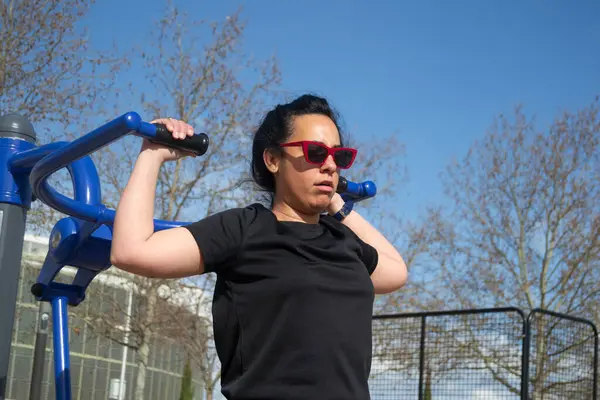 Omuz egzersizlerinin ortasında bir kadın.