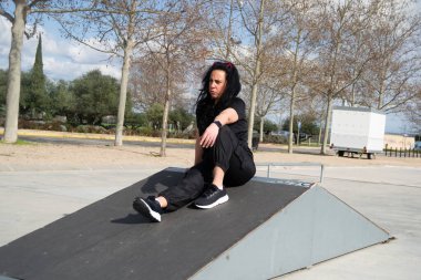 Bayan hemşire uzun bir vardiyadan sonra kaykay parkında mola veriyor, açık hava aktivitelerinin tadını çıkarıyor ve bacaklarını açıyor.