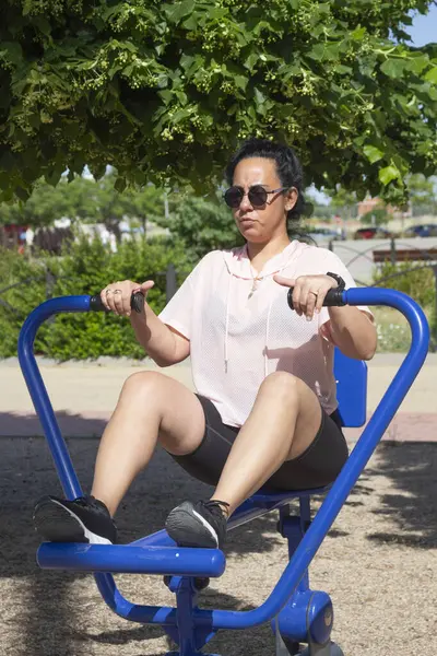 Güneşli bir günde biyo-sağlıklı bir parkta kürek çeken bir kadın antrenmanı.