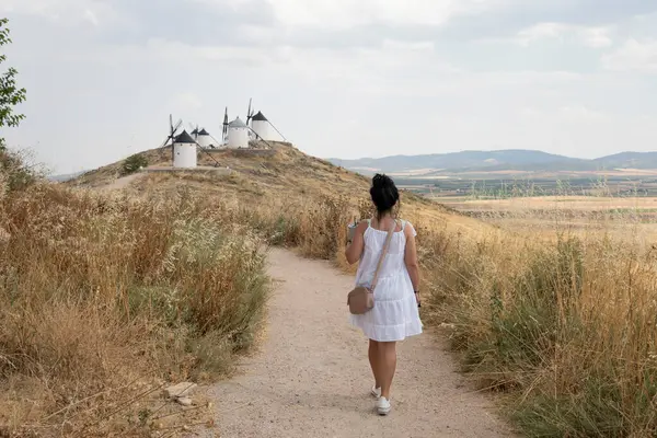 Tarihi yel değirmenlerine giden manzaralı yolu keşfeden kadın.