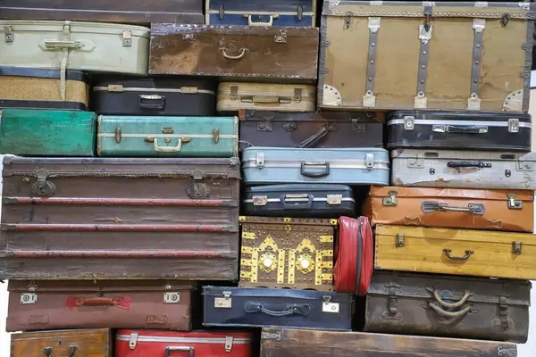 Renkli eski bavullar yığını. Retro dekoratif bavullar, yeni tatil planları ve seyahatler. Üst üste dizilmiş eski tarz bavullar.
