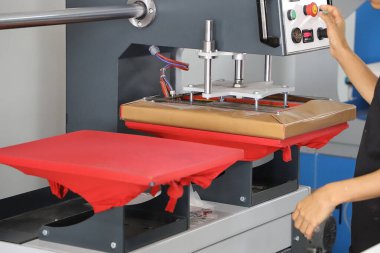Renkli tişörtlere baskı yap, kumaşlara resim basmak için bas. Erkek işçiler için tekstil yazdırırken büyük endüstriyel tekstil baskı makinesi.