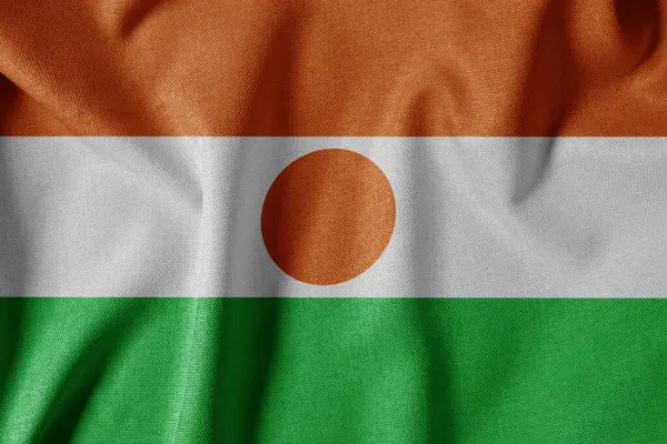 Dokulu Kumaş Arkaplanı Ulusal Bayrağı. İpek desenli bayrak, gerçekçi dalga ve bayrak görünümü. NE Nijer Bayrağı