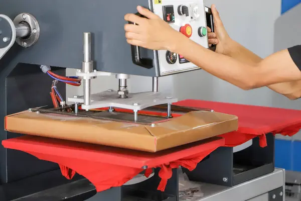 Renkli tişörtlere baskı yap, kumaşlara resim basmak için bas. Erkek işçiler için tekstil yazdırırken büyük endüstriyel tekstil baskı makinesi.