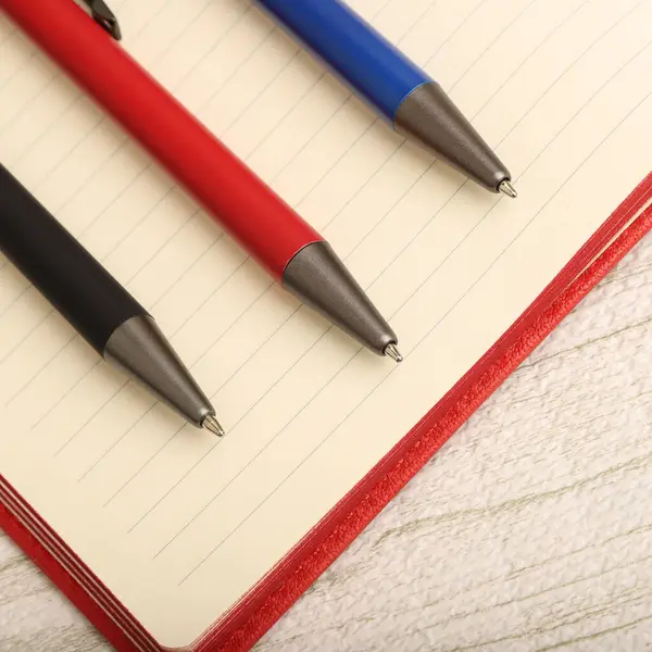 Canlı Dekoratif Arkaplanlı Zarif Kalem Açık Not Defteri, konsept fikir fotoğrafı. Masa resmi çalış, üst görünüm.