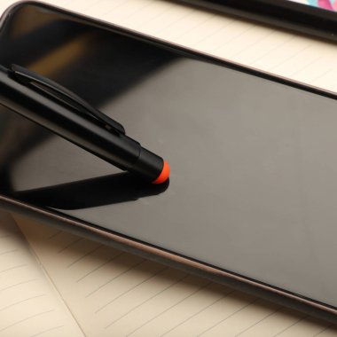Pen Stylus 'un yakın plan görüntüsü telefonun parlak bir yüzeyinde dinleniyor, dokunmatik ekran stili..