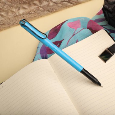 Canlı Dekoratif Arkaplanlı Zarif Kalem Açık Not Defteri, konsept fikir fotoğrafı. Masa resmi çalış, üst görünüm.