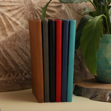 Renkli bantlı ve kalemli siyah defterler.