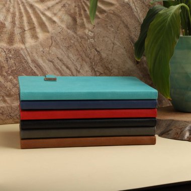 Renkli bantlı ve kalemli siyah defterler.