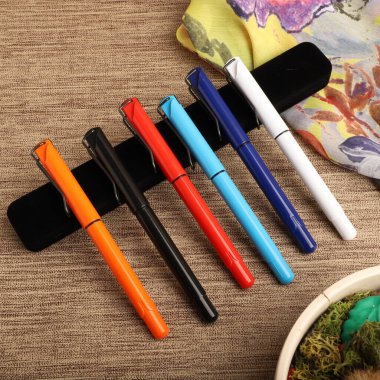Colorful Assorted Pens Arranged Neatly on a Textured Surface clipart