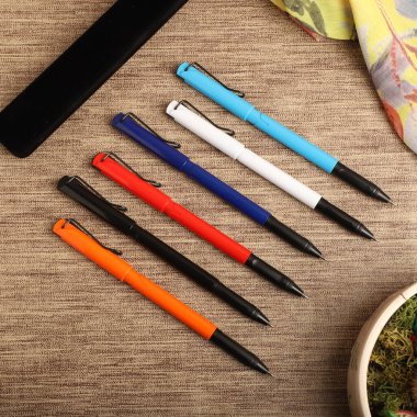Colorful Assorted Pens Arranged Neatly on a Textured Surface clipart