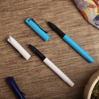 Colorful Assorted Pens Arranged Neatly on a Textured Surface clipart