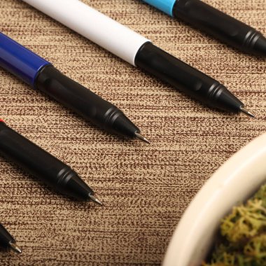 Colorful Assorted Pens Arranged Neatly on a Textured Surface clipart