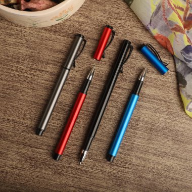 Colorful Assorted Pens Arranged Neatly on a Textured Surface clipart