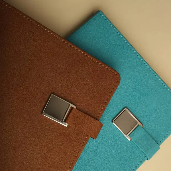 Renkli bantlı ve kalemli siyah defterler.