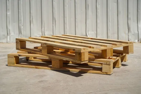 Açık bir günde, endüstriyel bir alanda istiflenmiş ahşap paletler.