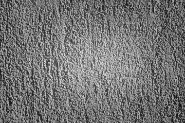 Tarafsız bir arkaplan veya mimari, iç tasarım veya sanatsal projeler için materyal referans olarak uygun kaba, dokulu bir yüzeye sahip beyaz bir duvarın yakın çekim görüntüsü.