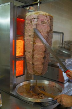 Geleneksel Türk et donörü veya shawarma için et kesen bir şefin yakın çekimi. Sokak yemekleri konsepti. İstanbul 'da et bağışçısı.