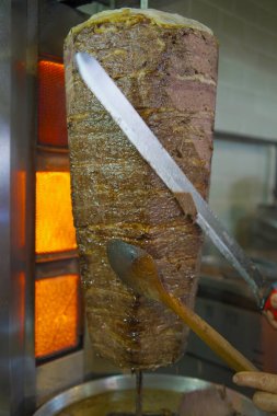 Geleneksel Türk et donörü veya shawarma için et kesen bir şefin yakın çekimi. Sokak yemekleri konsepti. İstanbul 'da et bağışçısı.