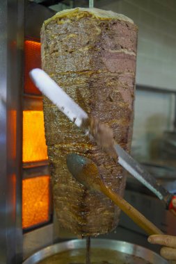 Geleneksel Türk et donörü veya shawarma için et kesen bir şefin yakın çekimi. Sokak yemekleri konsepti. İstanbul 'da et bağışçısı.